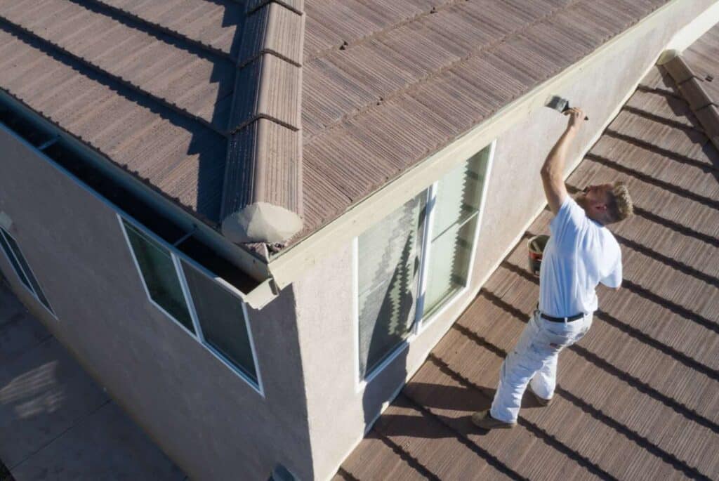 a man painting a roof