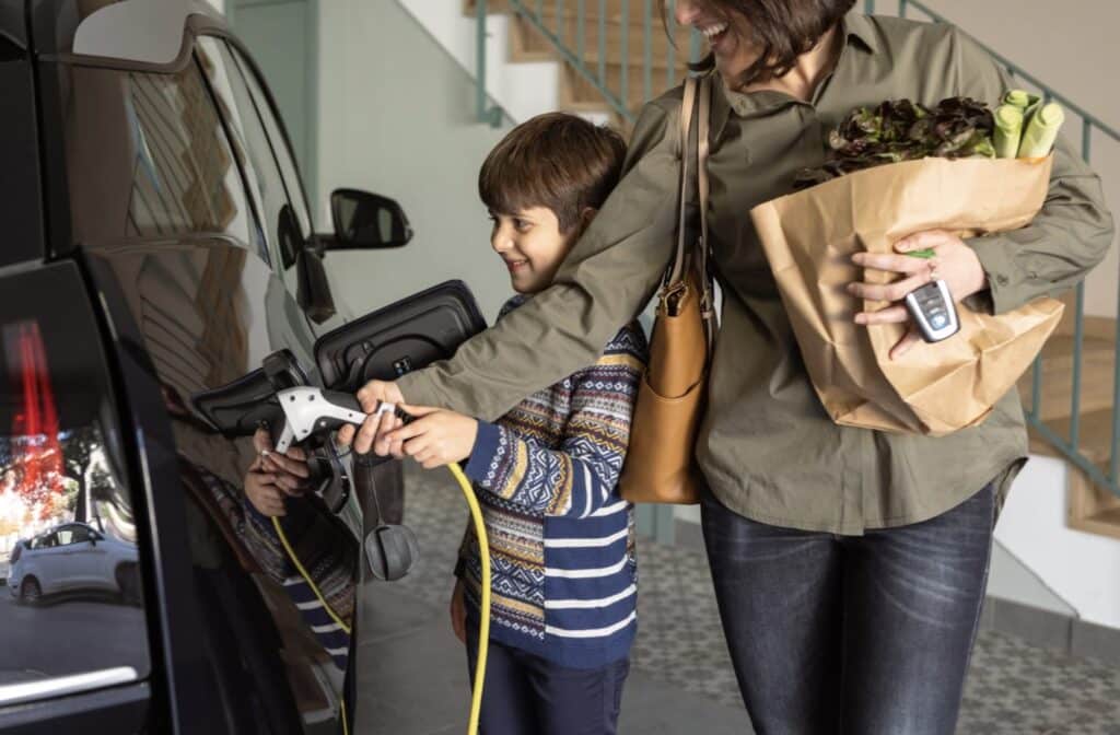 a woman and a child holding a hose and a bag